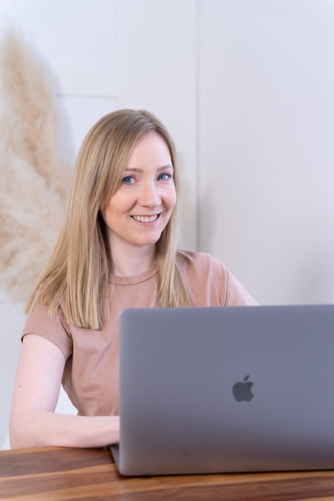 Csilla webdizájner a laptopja mögött mosolyog