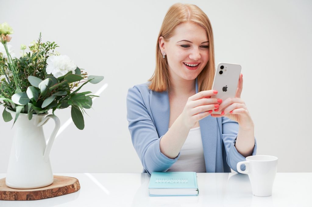 Dóri marketingszakértő mosolyogva nézi a telefonját