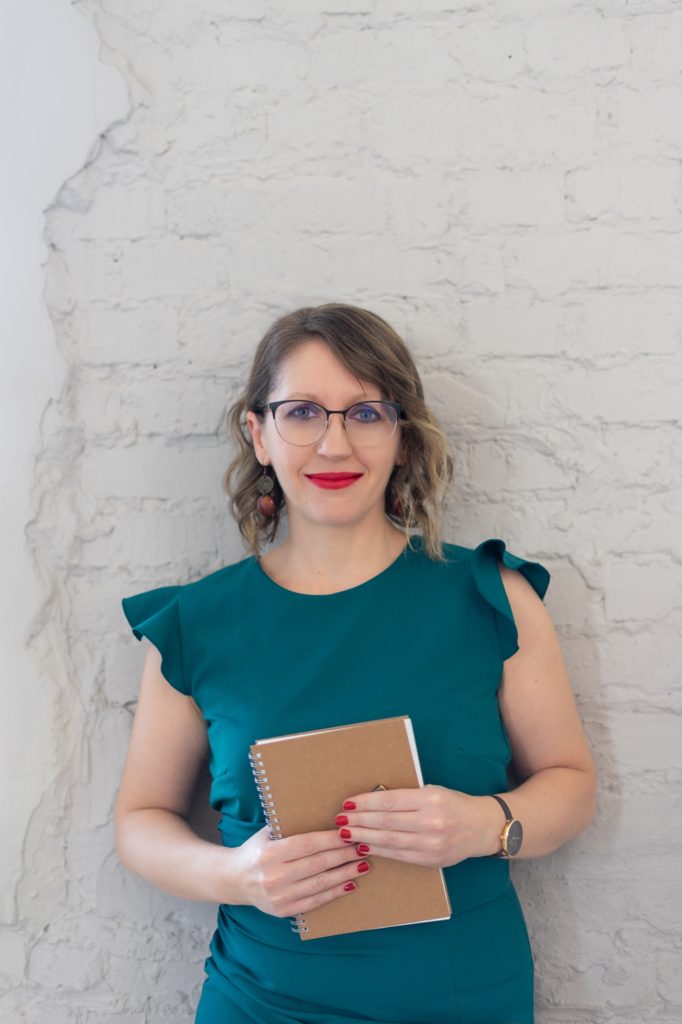 Júlia virtuális asszisztens könyvvel a kezében mosolyog