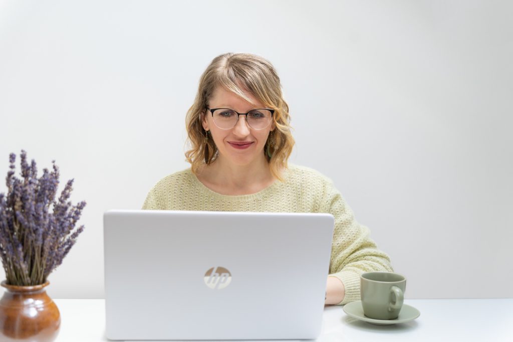 Júlia virtuális asszisztens a laptopja mögött mosolyog, mellette levendula
