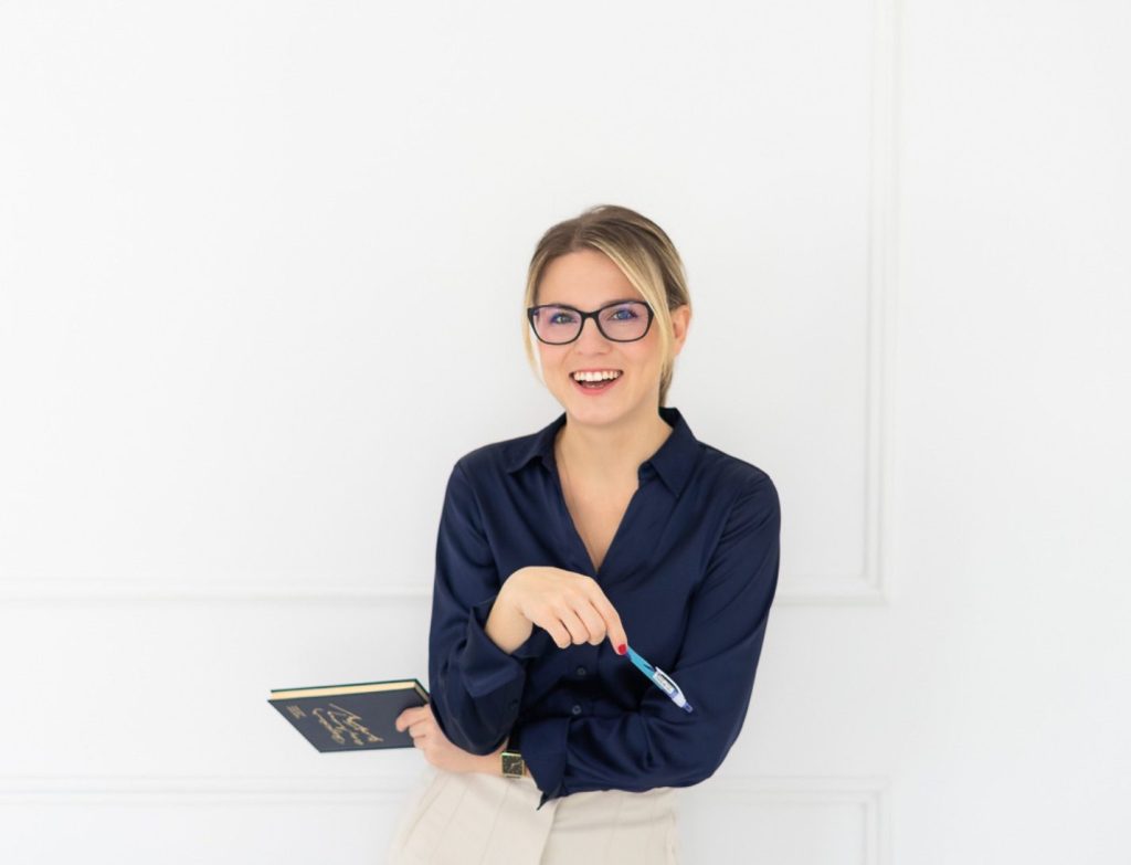 Vivi marketingszakértő sötétkék blúzban, könyvvel a kezében – női üzleti portré