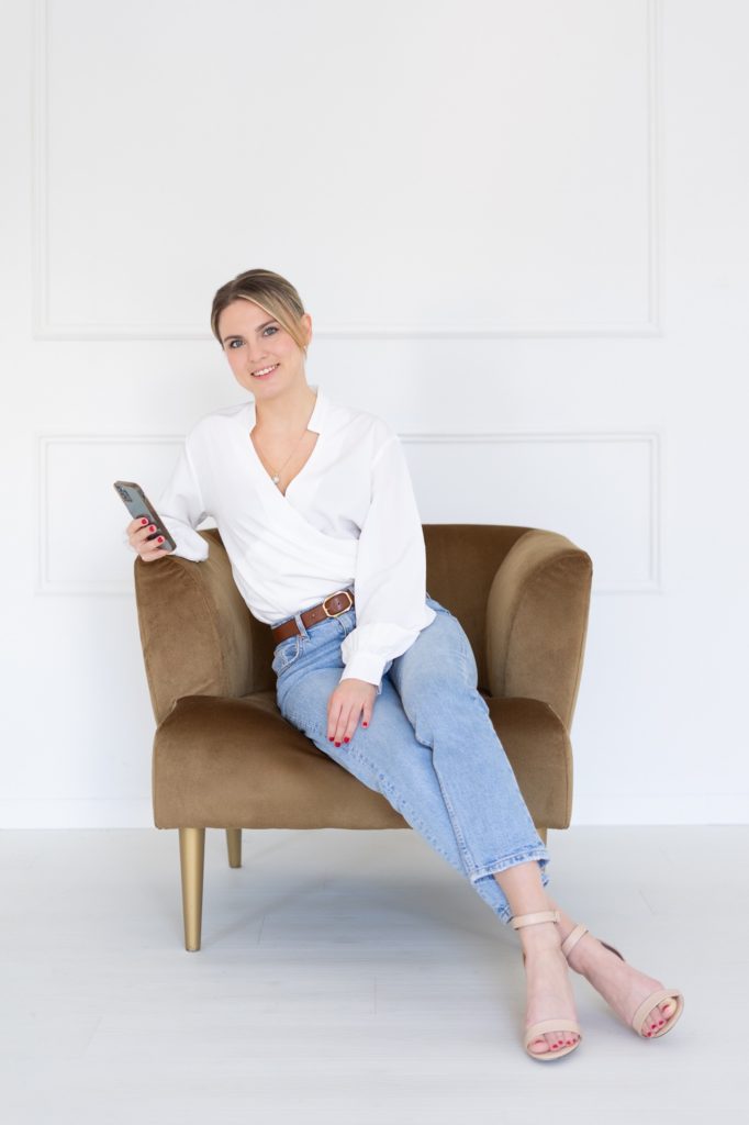 Vivi marketingszakértő egy fotelben ül, kezében telefon