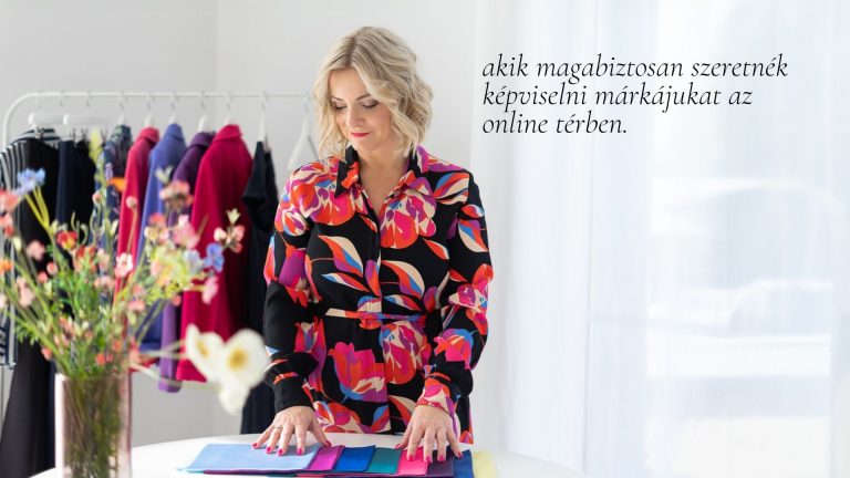 Vállalkozónő színes, mintás ruhában anyagmintákat válogat egy ruhaállvány előtt